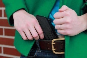 Woman Pulling Concealed Weapon From Pants